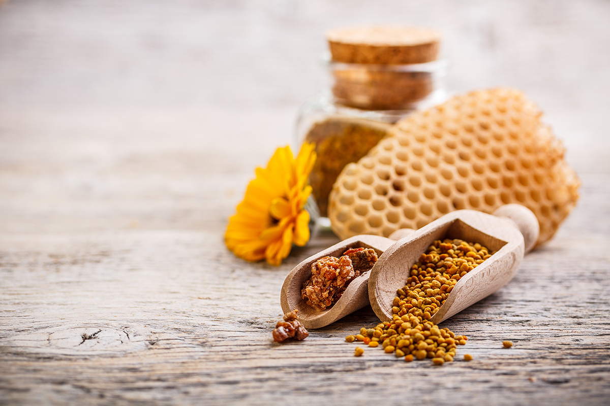Bee pollen granules and propolis in wooden scoop